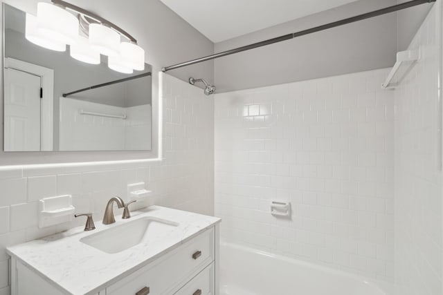 full bathroom with vanity, shower / tub combination, tile walls, and tasteful backsplash