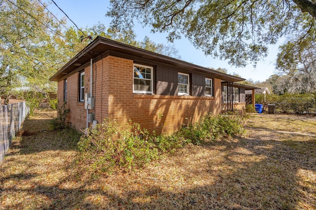 view of home's exterior with fence and brick siding