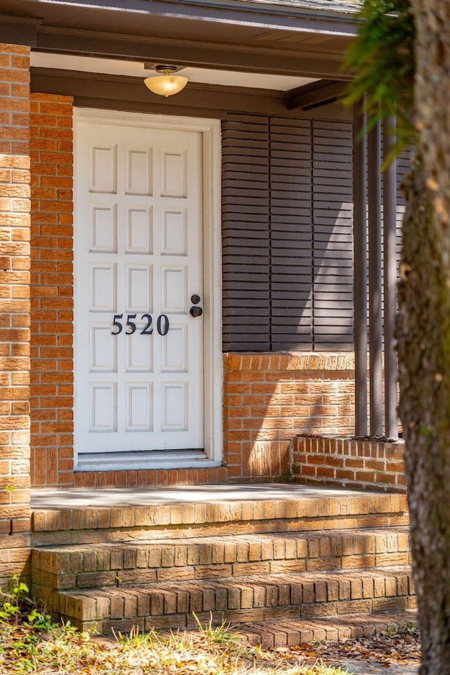 doorway to property featuring brick siding