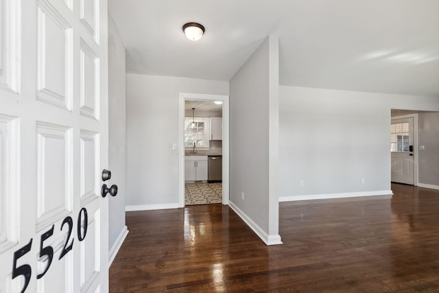 foyer entrance with baseboards and wood finished floors