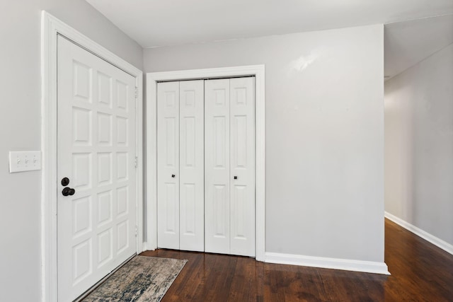 foyer entrance featuring baseboards and dark wood-style floors