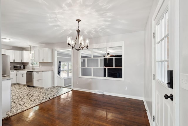 kitchen with baseboards, visible vents, stainless steel appliances, hardwood / wood-style flooring, and white cabinetry