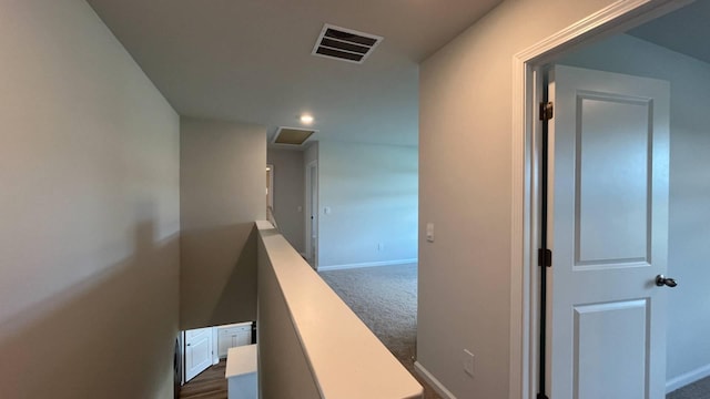 hallway featuring dark colored carpet