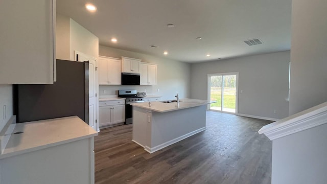 kitchen featuring dark wood-type flooring, an island with sink, white cabinets, and appliances with stainless steel finishes