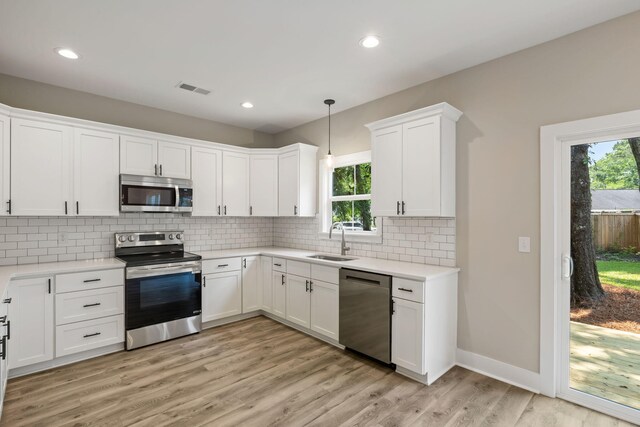 2960 Blackfish Rd, Johns Island, SC 29455 - kitchen with stainless steel appliances, a sink, tasteful backsplash, white cabinetry, and light countertops