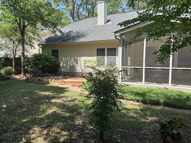 1578 Harborsun Dr, Charleston, SC 29412 - back of house with a sunroom, a yard, and a chimney