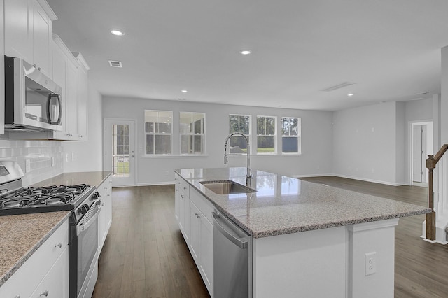 kitchen featuring stainless steel appliances, a sink, dark wood finished floors, baseboards, and recessed lighting