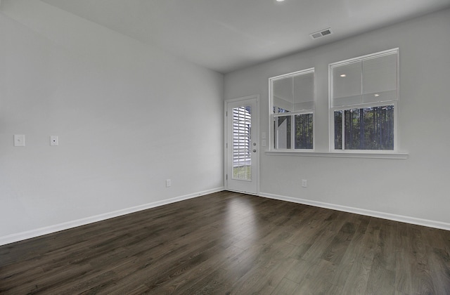 empty room with baseboards and dark wood finished floors