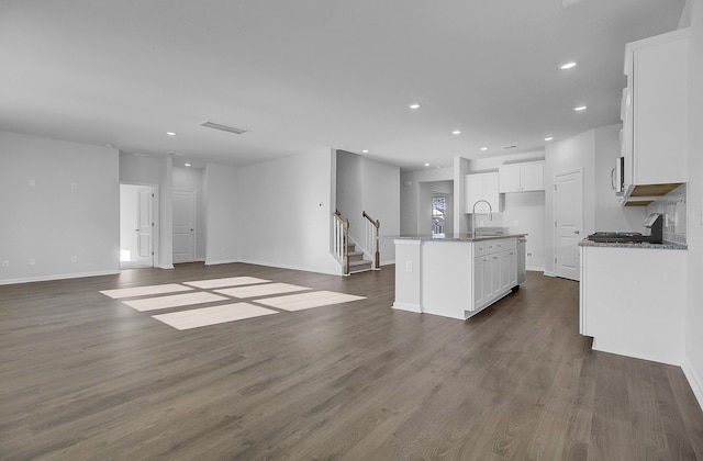 kitchen featuring open floor plan, white cabinets, appliances with stainless steel finishes, dark wood finished floors, and recessed lighting