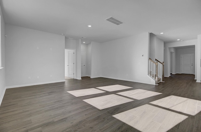 spare room with recessed lighting, baseboards, dark wood-style floors, and stairs