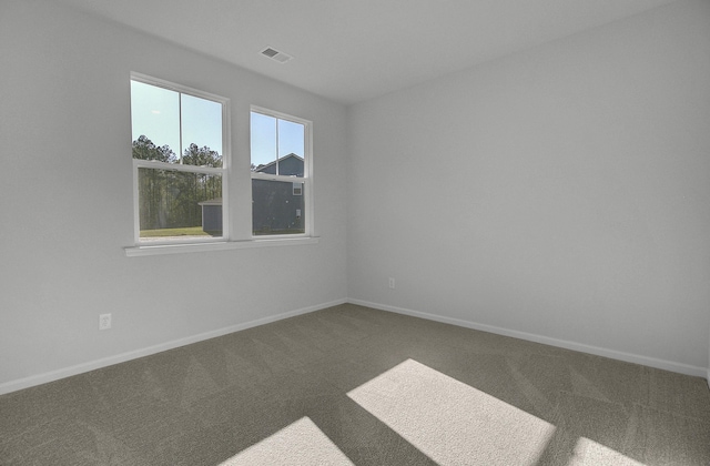empty room featuring carpet and baseboards