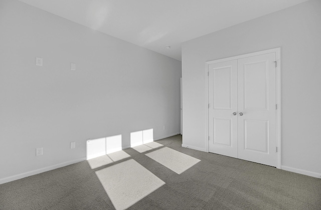 unfurnished bedroom with carpet, baseboards, and a closet