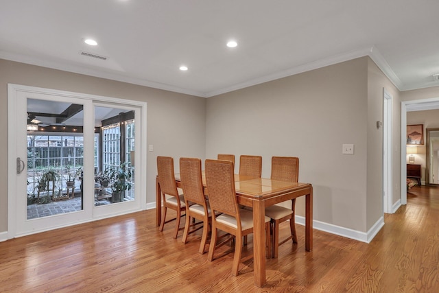 dining area featuring ornamental molding and light wood-type flooring