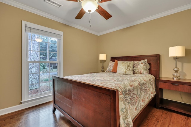 bedroom with dark wood-type flooring, ornamental molding, and ceiling fan