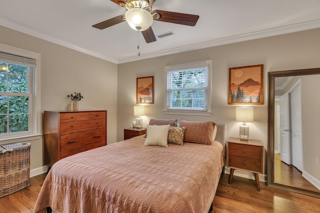 bedroom with hardwood / wood-style floors, crown molding, and ceiling fan