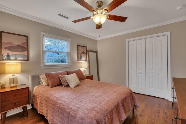 bedroom with dark wood-type flooring, ornamental molding, and a closet