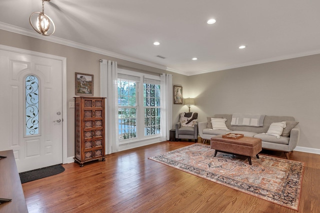 living room with ornamental molding, a chandelier, and hardwood / wood-style floors