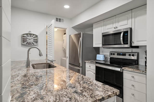 kitchen with white cabinets, light stone countertops, sink, and appliances with stainless steel finishes