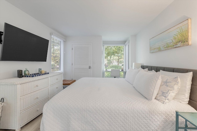 bedroom with light hardwood / wood-style floors and multiple windows