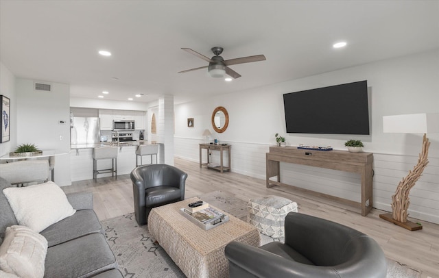 living room with light wood-type flooring and ceiling fan