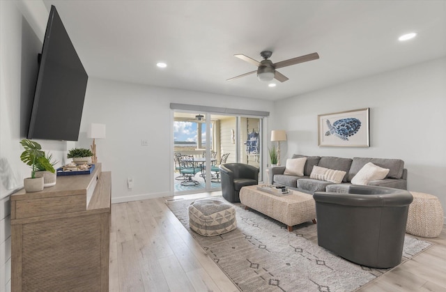 living room with ceiling fan and light hardwood / wood-style flooring