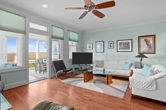 living area with a ceiling fan, wood finished floors, baseboards, recessed lighting, and crown molding