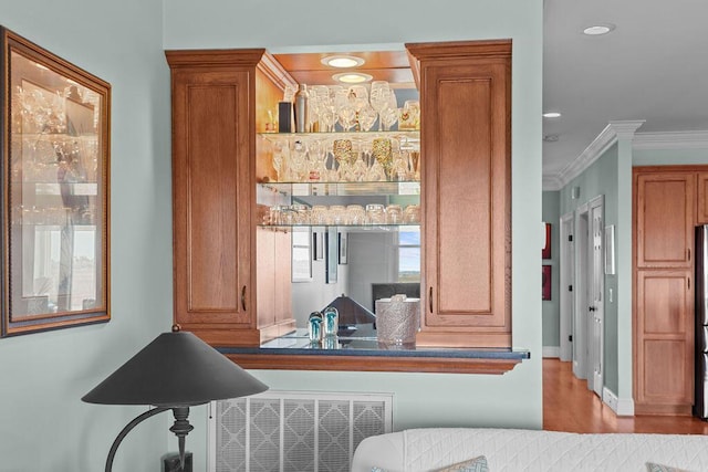 room details with fridge, baseboards, ornamental molding, and wood finished floors