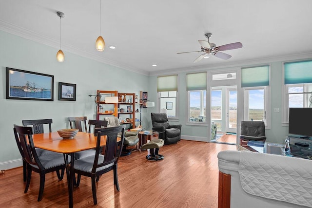 dining room with a wealth of natural light, wood finished floors, baseboards, and ornamental molding