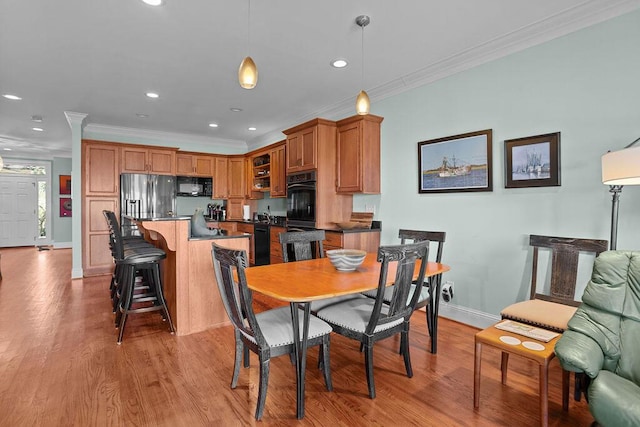 dining area featuring recessed lighting, light wood-type flooring, baseboards, and crown molding