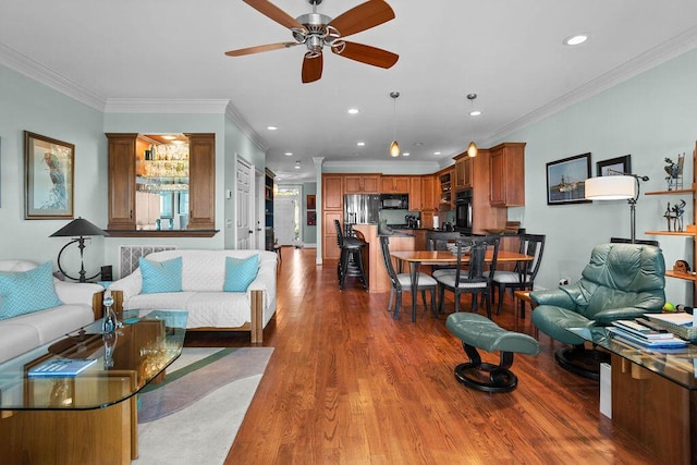 living area featuring recessed lighting, crown molding, a ceiling fan, and wood finished floors