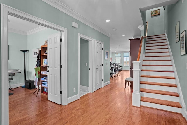 interior space featuring recessed lighting, baseboards, wood finished floors, and crown molding