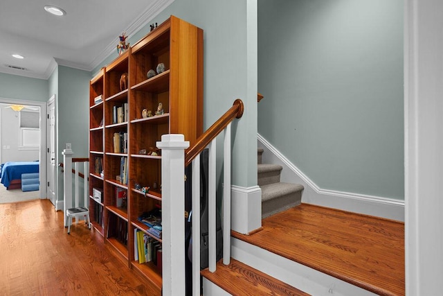 staircase with visible vents, baseboards, ornamental molding, recessed lighting, and wood finished floors