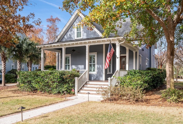 view of front of house featuring a ceiling fan, covered porch, and a shingled roof