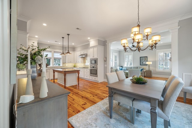 dining area featuring recessed lighting, visible vents, light wood-style flooring, ornamental molding, and ornate columns