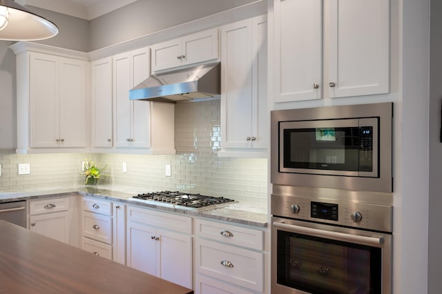 kitchen featuring appliances with stainless steel finishes, backsplash, white cabinetry, and under cabinet range hood