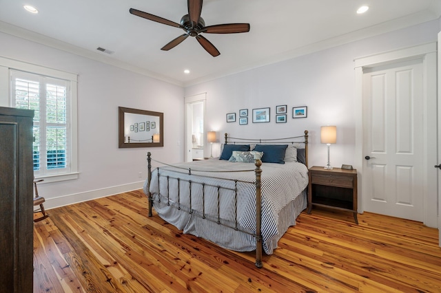 bedroom featuring light wood finished floors, recessed lighting, visible vents, ornamental molding, and baseboards