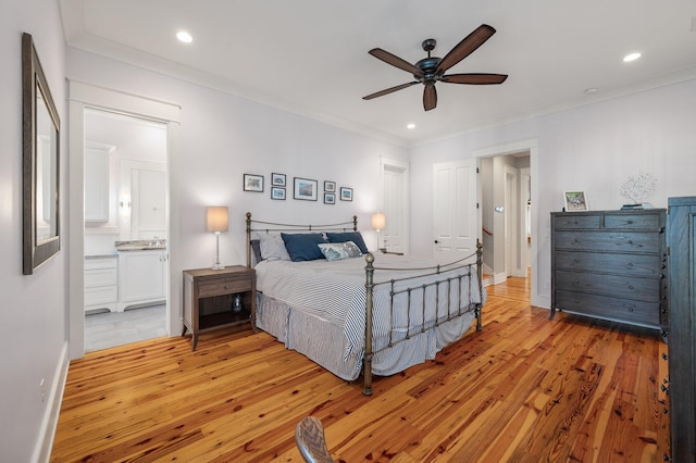 bedroom with recessed lighting, light wood-type flooring, connected bathroom, and crown molding