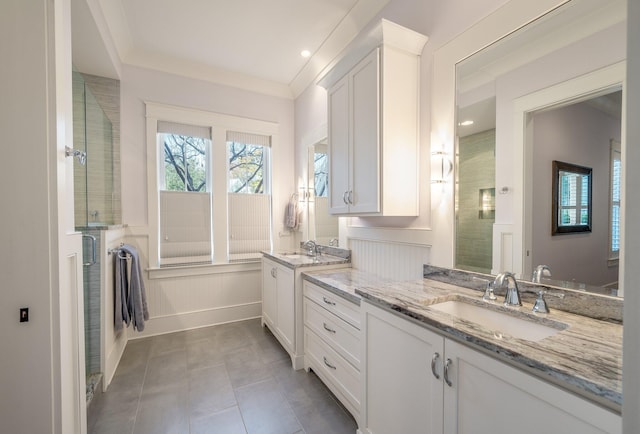 full bathroom with ornamental molding, tile patterned floors, a sink, an enclosed shower, and two vanities