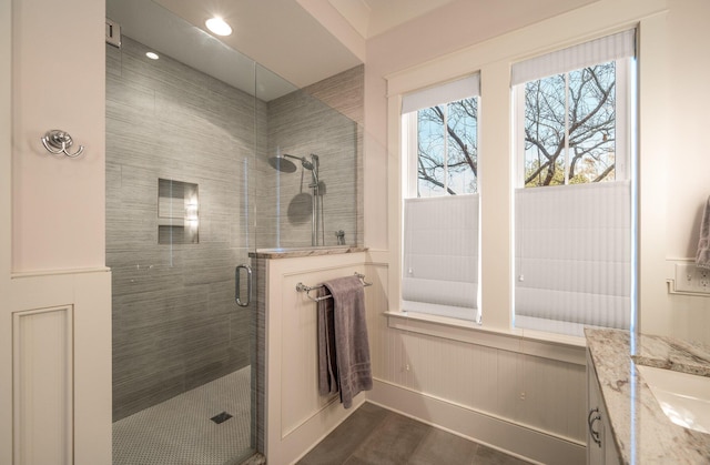 full bathroom featuring a stall shower, wood finished floors, and vanity