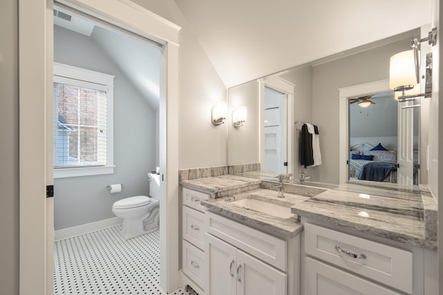 bathroom with lofted ceiling, toilet, vanity, baseboards, and ensuite bath