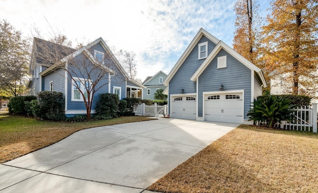 view of front of home with concrete driveway, fence, and a front lawn