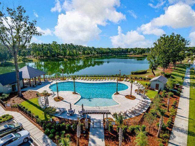 pool with a patio, a water view, and an outdoor structure