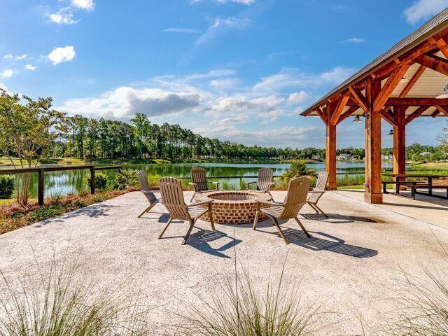 view of patio featuring a water view, a fire pit, and a gazebo