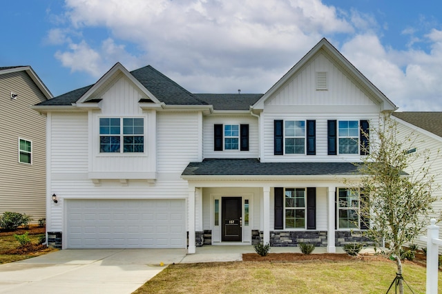 view of front of property with a porch, a garage, and a front lawn