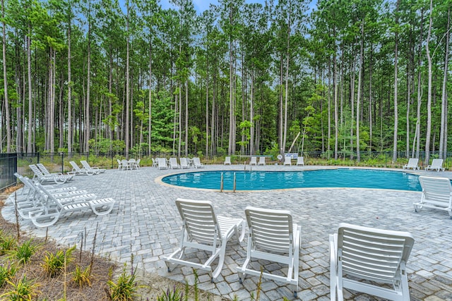 pool with fence and a patio