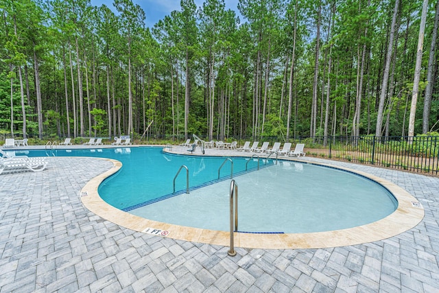 community pool featuring a patio area and fence