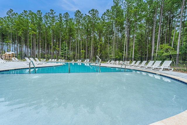 community pool with a patio and fence