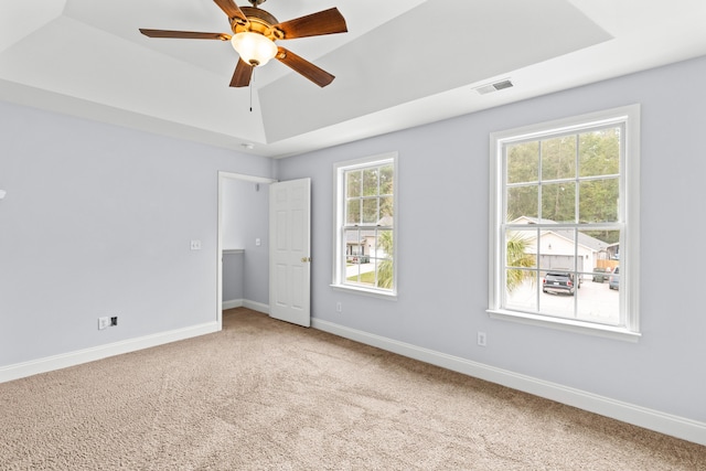 unfurnished bedroom with carpet floors, a raised ceiling, and ceiling fan