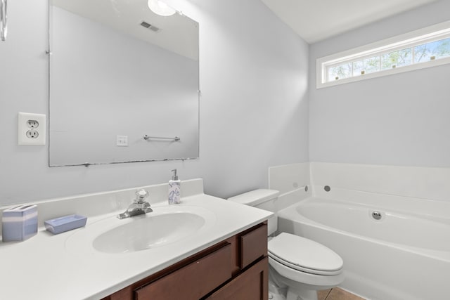 bathroom featuring a washtub, vanity, and toilet