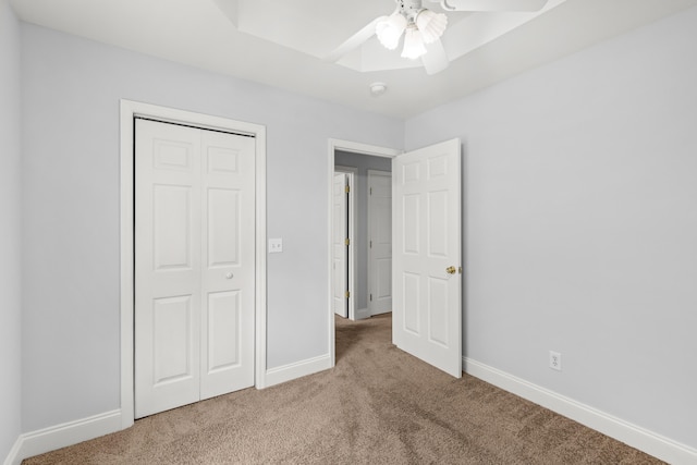 unfurnished bedroom featuring carpet floors, ceiling fan, and a closet